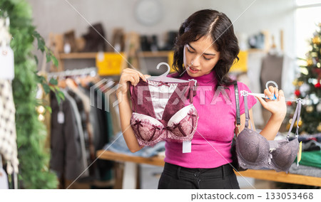 Asian woman chooses underwear or bra in clothing store before Christmas Asian woman chooses underwear or bra in clothing store before Christmas 133053468