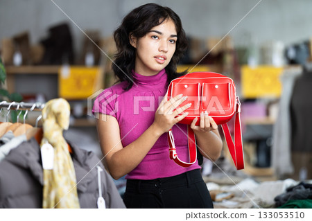 Filipino woman chooses a stylish handbag at Christmas sale Filipino woman chooses a stylish handbag at Christmas sale 133053510