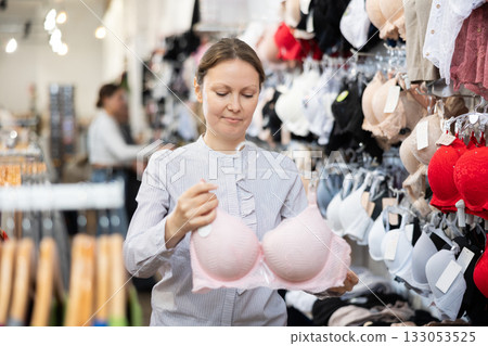 Middle-aged woman choosing convenient bra in clothing store Middle-aged woman choosing convenient bra in clothing store 133053525