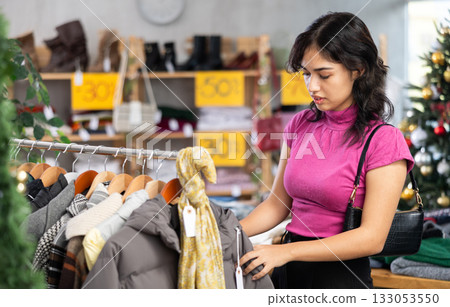 Asian woman choosing jackets and coats in a clothing store 133053550