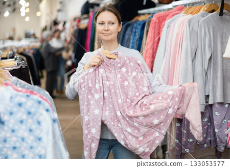 Positive female customers shopping in clothing store with warm clothing Positive female customers shopping in clothing store with warm clothing 133053577