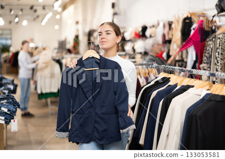 Young girl choosing convenient blazer in clothing store Young girl choosing convenient blazer in clothing store 133053581