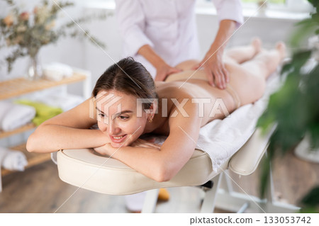 Young woman clinet satisfied with work of masseuse Young woman clinet satisfied with work of masseuse 133053742