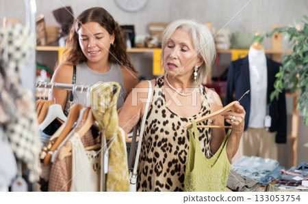 Elderly and young women choosing summer clothes in store 133053754