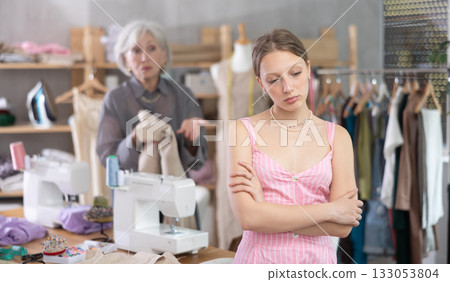 Mature dressmaker scolds assistant at work Mature dressmaker scolds assistant at work 133053804