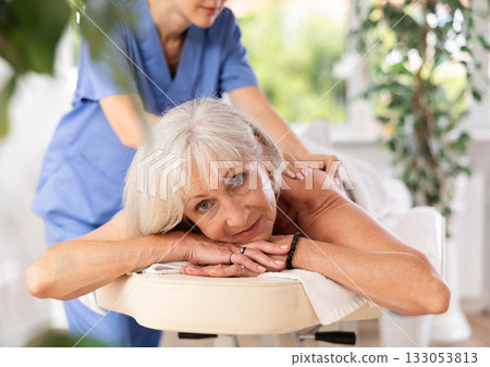 Elderly woman enjoying massage from professional female masseur Elderly woman enjoying massage from professional female masseur 133053813