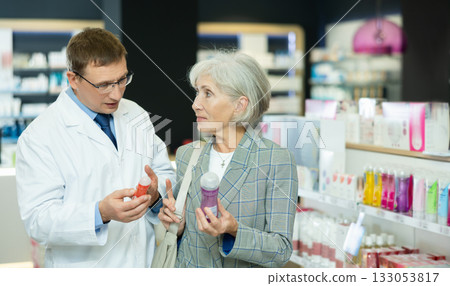 Male pharmacist gives advice to mature woman on what product intimate hygiene to buy for personal hygiene 133053817