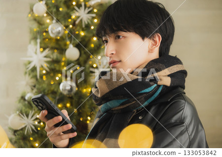 一個男人拿著禮物在聖誕樹前 133053842