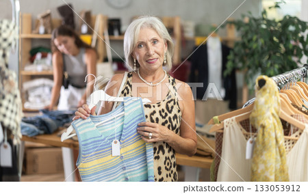 Elderly woman choosing vest in clothing store 133053912