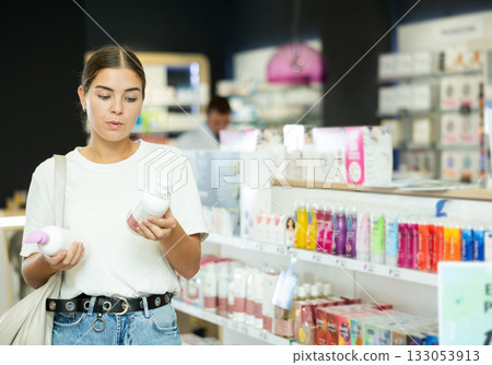 Girl customer chooses gel for intimate hygiene in chemist shop 133053913