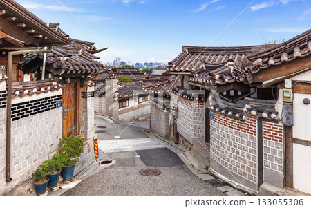 Korean traditional Hanok street with the modern city skyline visible in the distance from this famous cultural landmark Korean traditional Hanok street with the modern city skyline visible in the distance from this famous cultural landmark 133055306