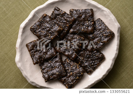 日式盤子上的黑芝麻米餅 日式盤子上的黑芝麻米餅 133055621