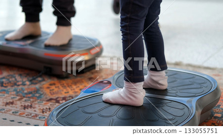 Parent with child participate in a training session using vibration platforms innovations in sports and massage Parent with child participate in a training session using vibration platforms innovations in sports and massage 133055751