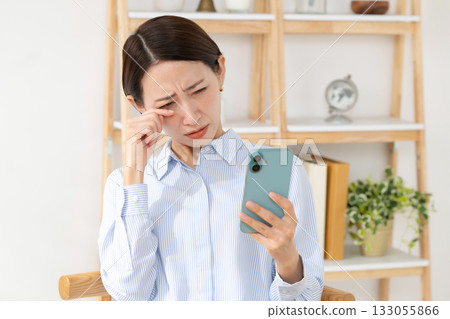 A woman watching a smartphone 133055866