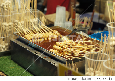 Many pork balls on the bamboo stick dipping in the spicy sauce for selling in the night flea market 133055913