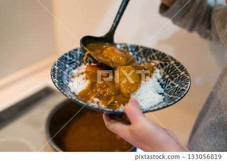 A child serving himself curry A child serving himself curry 133056819