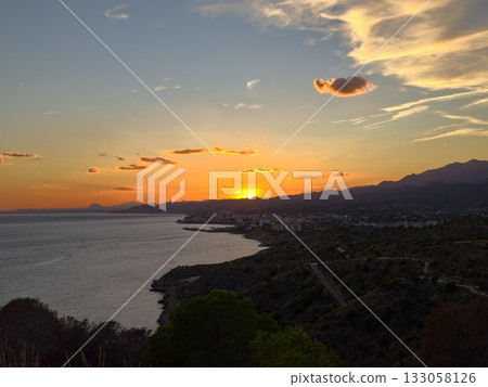 colorful coastal scene, peaceful seascape with glowing village lights and soft cloud reflections 133058126