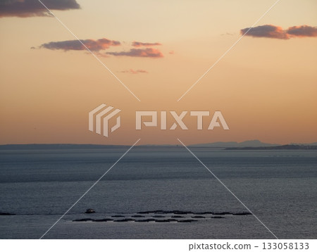 relaxing sunset over smooth water with subtle cloud formations and minimalistic design elements 133058133