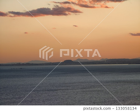 serene sunset panorama, tranquil evening coastal view, peaceful horizon with distant land 133058134