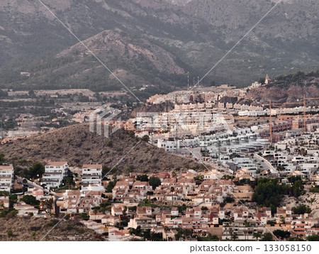 illuminated hillside town showcasing clustered masonry houses amid rugged mountain terrain 133058150