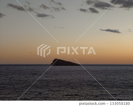 gentle evening sky over calm waters, dreamlike pink haze floats over serene sea during sunset hours 133058180