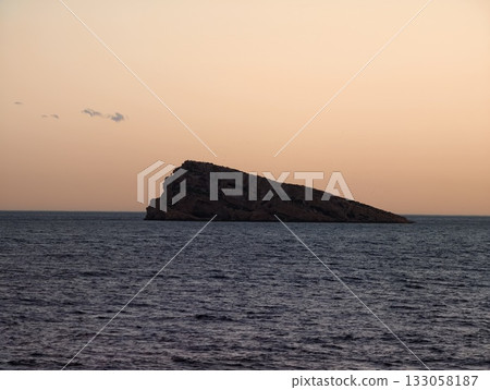 tranquil mountain scene at dusk, peaceful mountaintop shadows cast upon still sea during sunset tranquil mountain scene at dusk, peaceful mountaintop shadows cast upon still sea during sunset 133058187