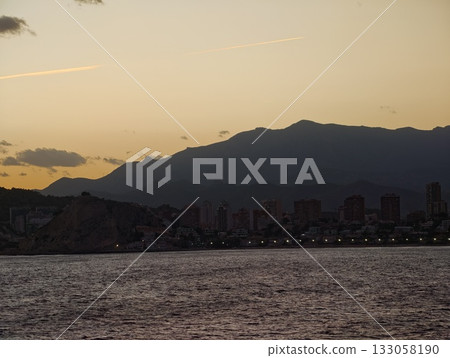 sunset over mountain harbor, serene dusk view featuring mountain outlines and shimmering waters sunset over mountain harbor, serene dusk view featuring mountain outlines and shimmering waters 133058190