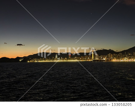 dusk scene with reflections and cityscape, nighttime view showcasing lights and water reflections 133058205