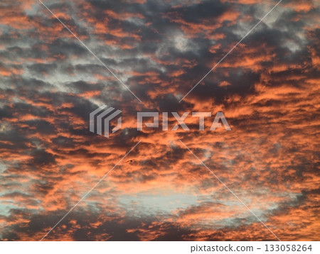 bright flames against dark shadows, dynamic fiery sky scene featuring contrasting light and dark 133058264