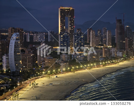 serene seaside evening, peaceful beachfront at dusk with glowing highrise structures and gentle serene seaside evening, peaceful beachfront at dusk with glowing highrise structures and gentle 133058276