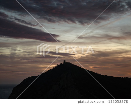 stormy fortress silhouette, silhouette of castle beneath stormy skies indicating tension and drama 133058278
