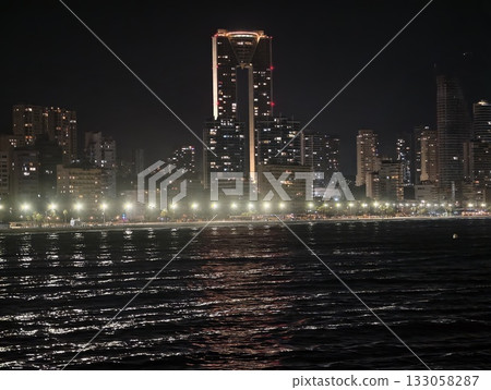 night city reflections, calm harbor scenes showcasing bright buildings and gentle ripples in water 133058287