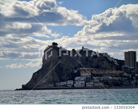 scenic seaside village nestled below towering fortress rock with lively waterfront scenery 133058304