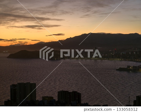 peaceful evening landscape, silent dusk over bay with silhouetted hills and gentle reflections peaceful evening landscape, silent dusk over bay with silhouetted hills and gentle reflections 133058312