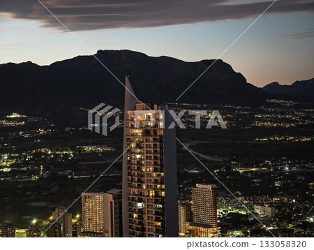 contemporary skyscraper visuals, sleek glass building with mountain background and illuminated contemporary skyscraper visuals, sleek glass building with mountain background and illuminated 133058320