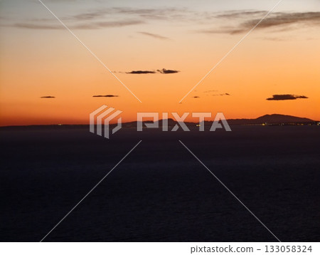 calm evening seascape, quiet evening horizon displaying gentle amber hues and sparse cloud cover calm evening seascape, quiet evening horizon displaying gentle amber hues and sparse cloud cover 133058324