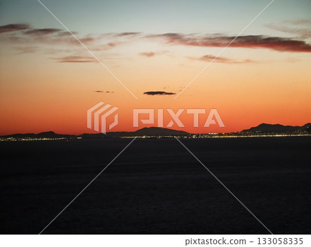 quiet horizon with city lights glowing faintly, peaceful evening with distant city skyline 133058335