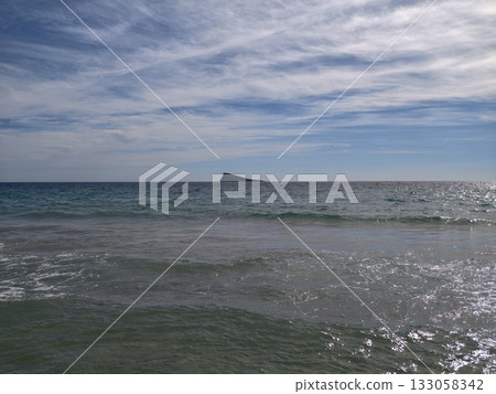 bright ocean with sandy beaches, sunlit coastline featuring gentle surf and tropical summery bright ocean with sandy beaches, sunlit coastline featuring gentle surf and tropical summery 133058342