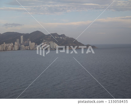 spectacular early morning view of peaceful coastal city with mountains and gentle water reflections 133058435