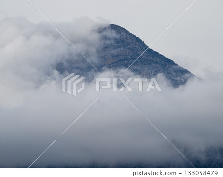 foggy mountain view, serene drone shot capturing secluded fogladen mountain ranges beneath cloudy 133058479