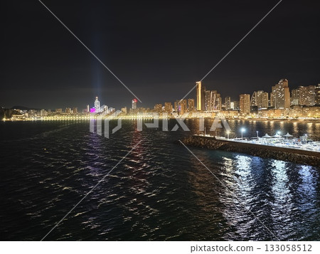 night cityscape illumination, flickering beams enhance festive atmosphere along bustling promenade night cityscape illumination, flickering beams enhance festive atmosphere along bustling promenade 133058512