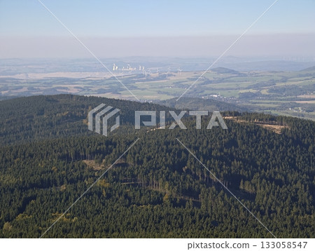 overview of mountainous woodland transitioning into open plains with distant city skyline and haze overview of mountainous woodland transitioning into open plains with distant city skyline and haze 133058547