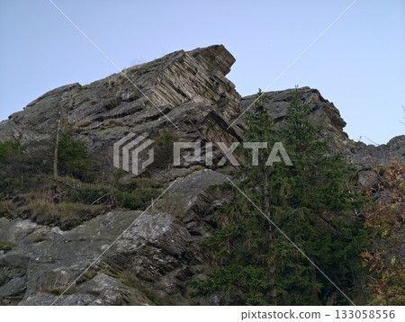 distinct rocky ridge with pine, cliffside stratification featuring lone pine amid rugged terrain 133058556