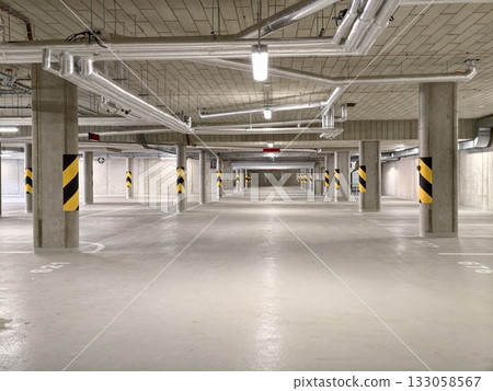 open cement lot with pipes, wide parking facility with visible ductwork and safety markings open cement lot with pipes, wide parking facility with visible ductwork and safety markings 133058567