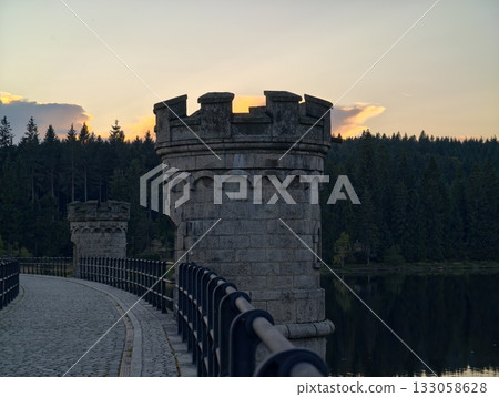 sunset turret scene, reflective water enhances tranquil ambiance of ancient guard tower at dusk 133058628