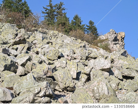 rocky hillside exploration, field researcher observes stone textures and erosion effects 133058666