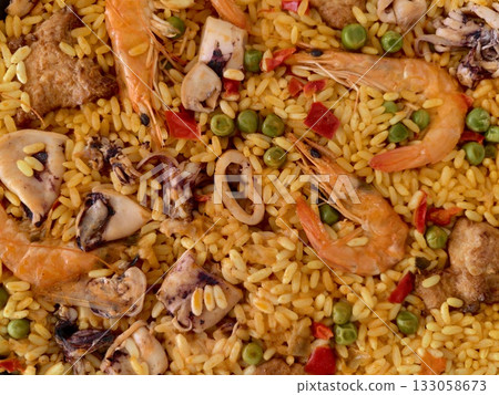 seafood paella feast, colorful seafood and vegetable rice dish served in communal pan for enjoyment 133058673