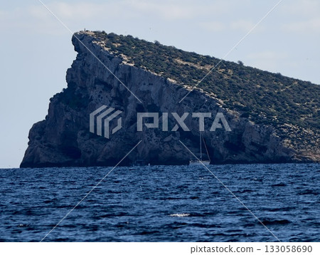 boat explores coast, vessel navigates rugged shoreline, small craft advances past rocky coastline 133058690