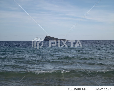 gentle surf caresses sandy coastal edges peacefully, quiet ocean waves meet soft sands under vast 133058692