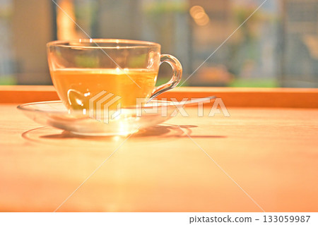 Relaxing tea time by the window with herbal tea in a glass cup Relaxing tea time by the window with herbal tea in a glass cup 133059987